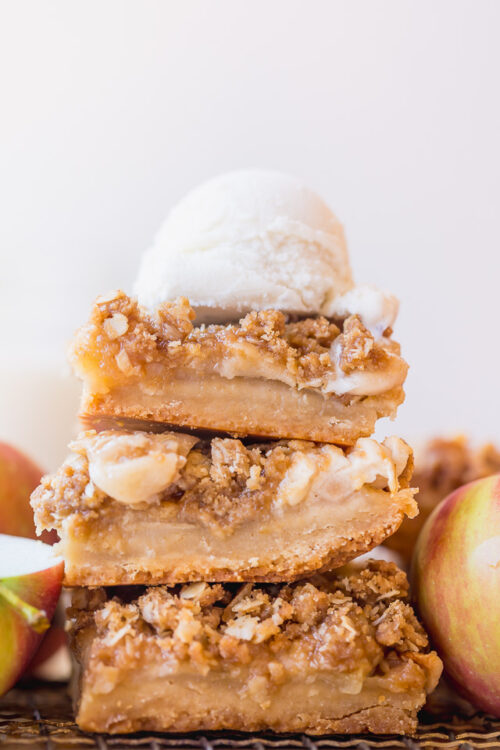 Apple Crisp Bars in a stack with vanilla ice cream on top.