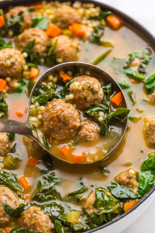 Italian Wedding Soup being ladled out of soup pot.